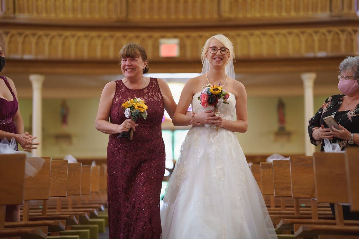 Bride walking down the church aisle holding her bouquet