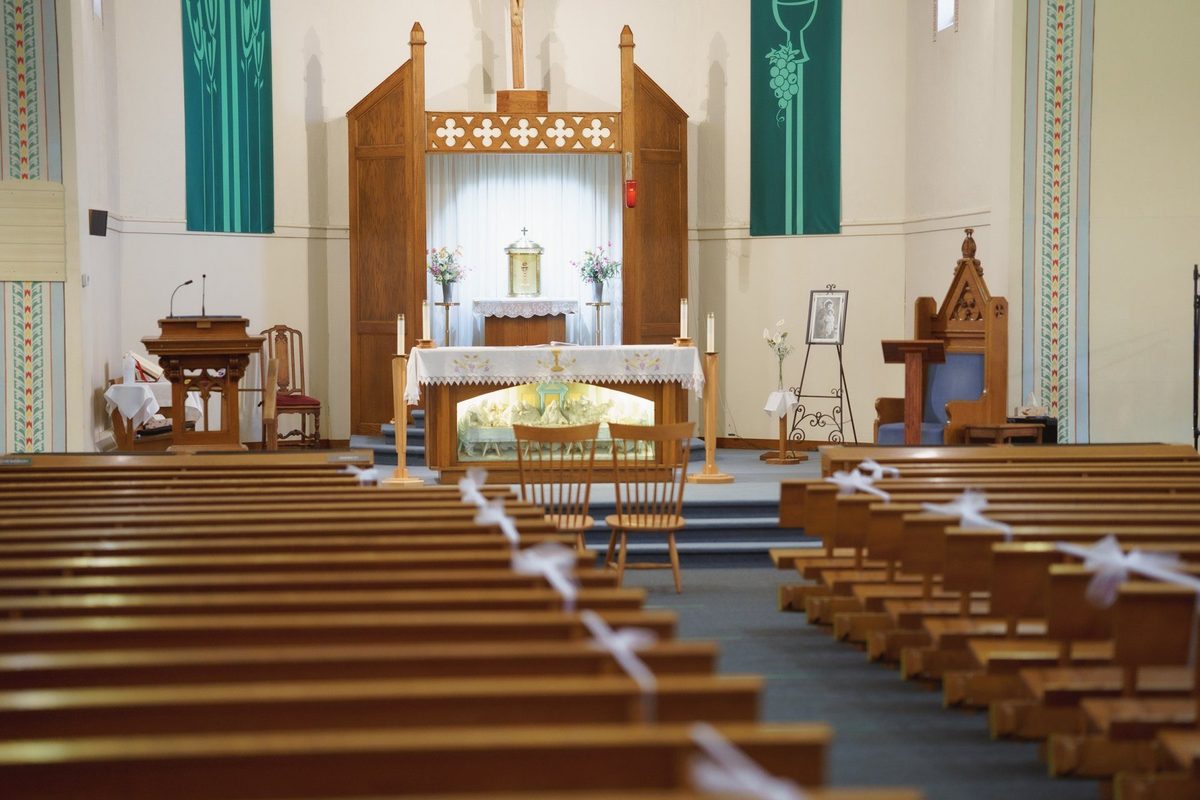 Church interior with wooden pews and altar before a wedding ceremony in Wallaceburg