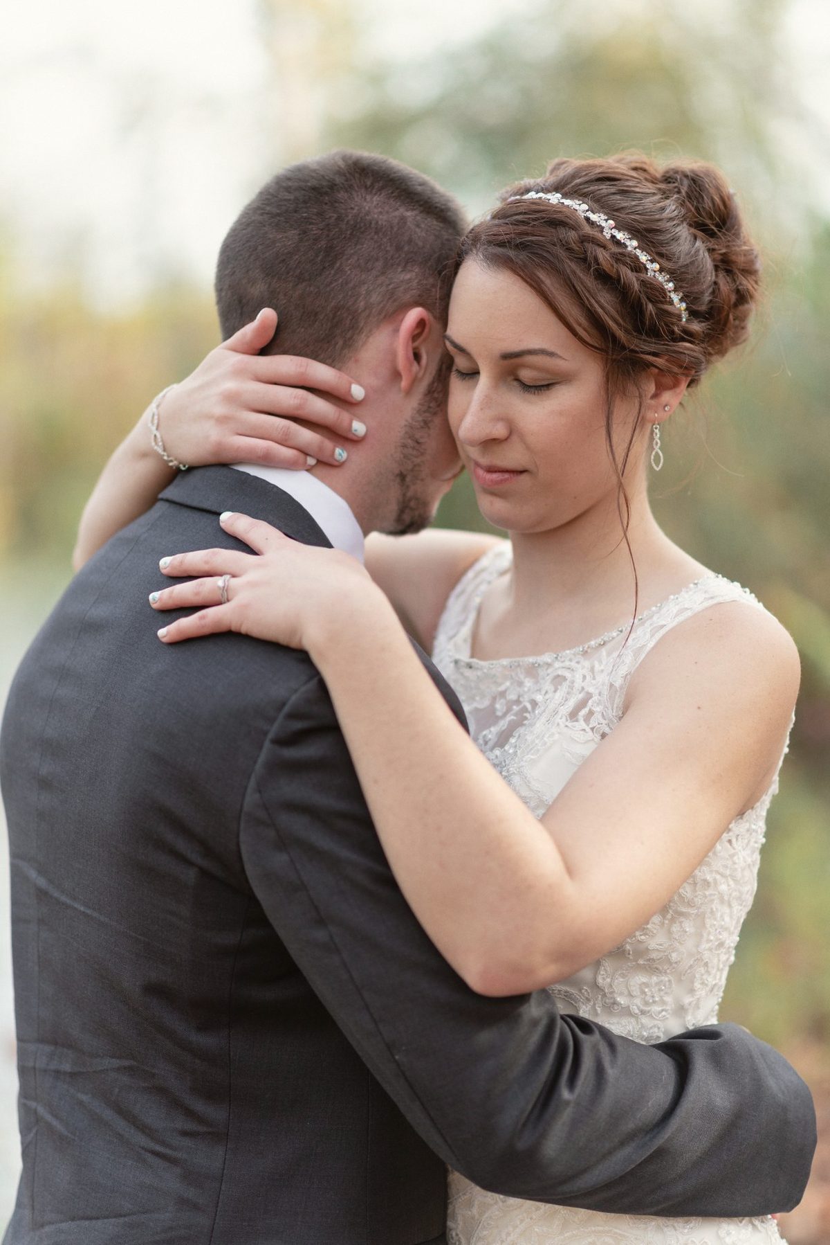 Bride with her eyes closed as she embraces the groom