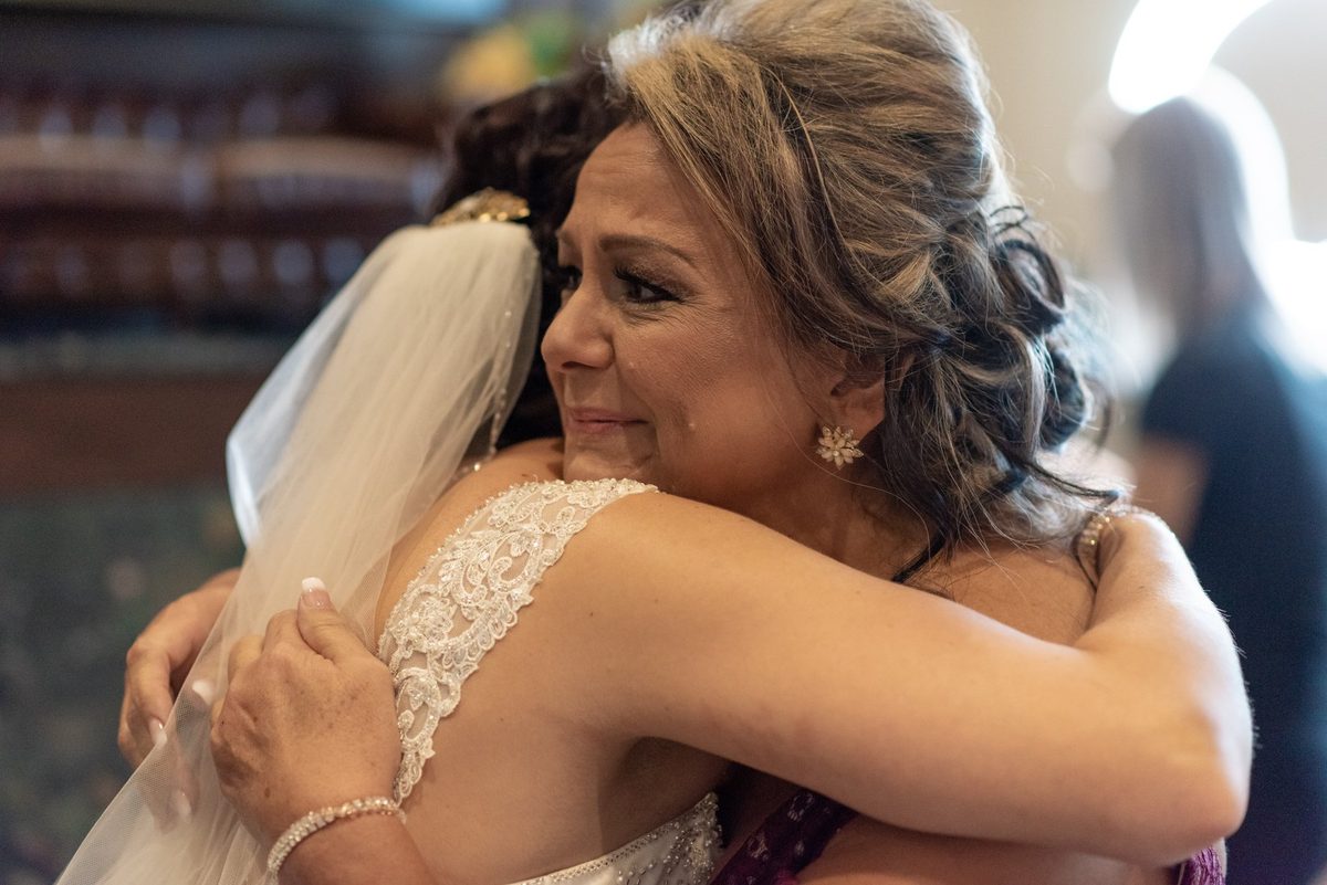 Bride hugging a teary-eyed guest at the reception