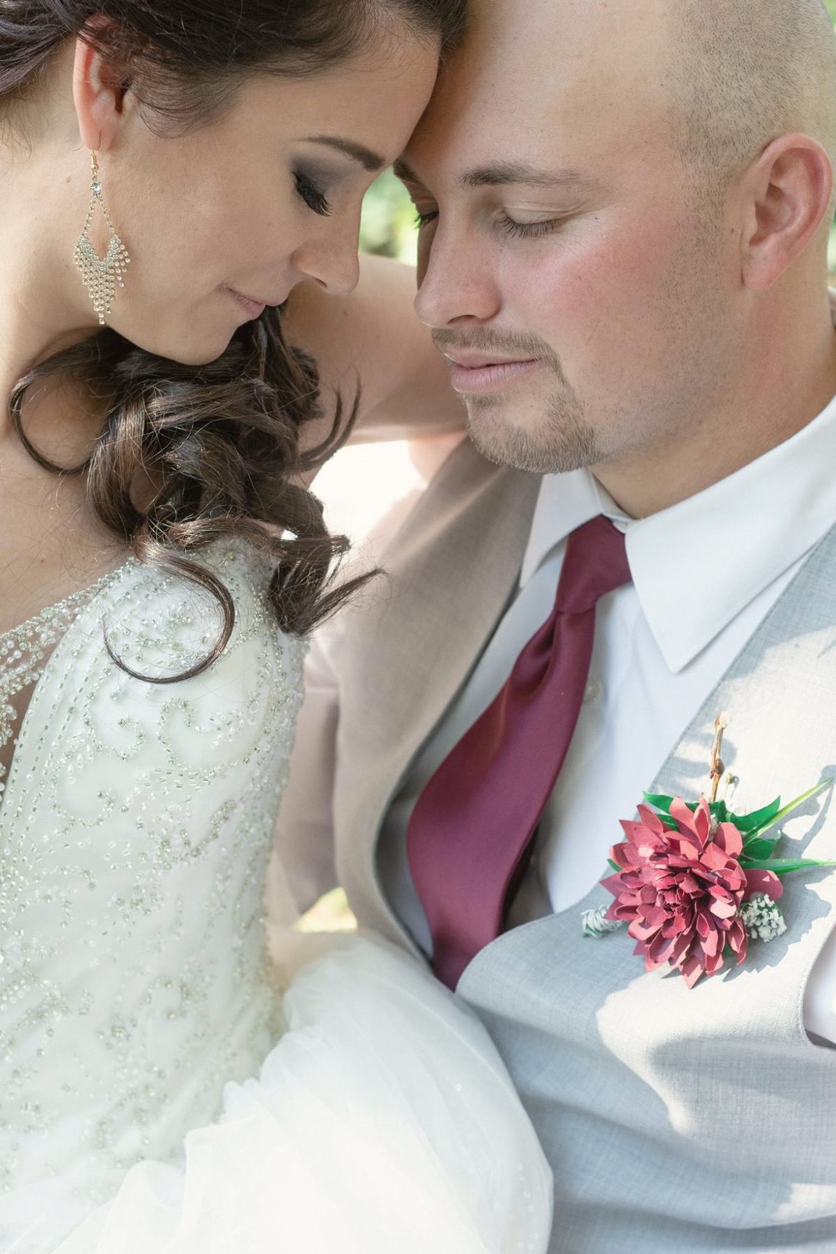 Bride resting her cheek against the groom's as they both close their eyes