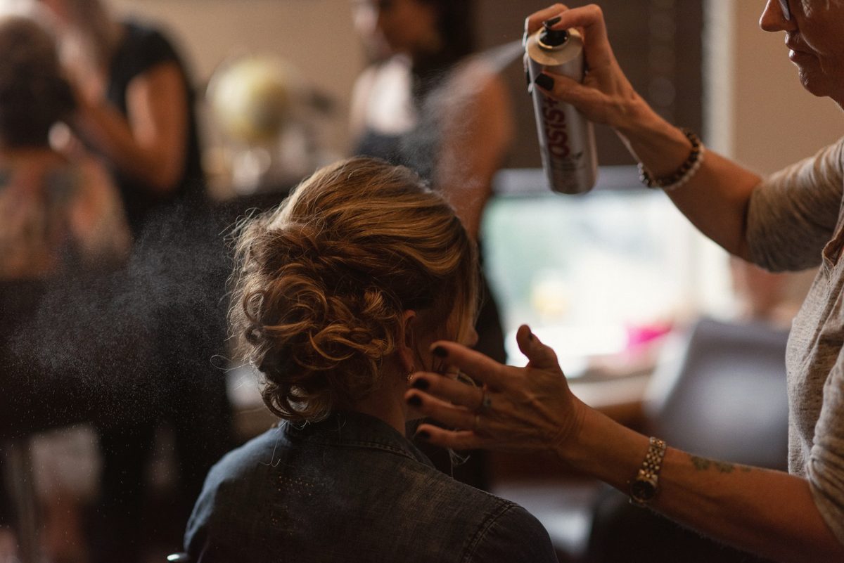 Bride's hair being set with hairspray as she gets ready