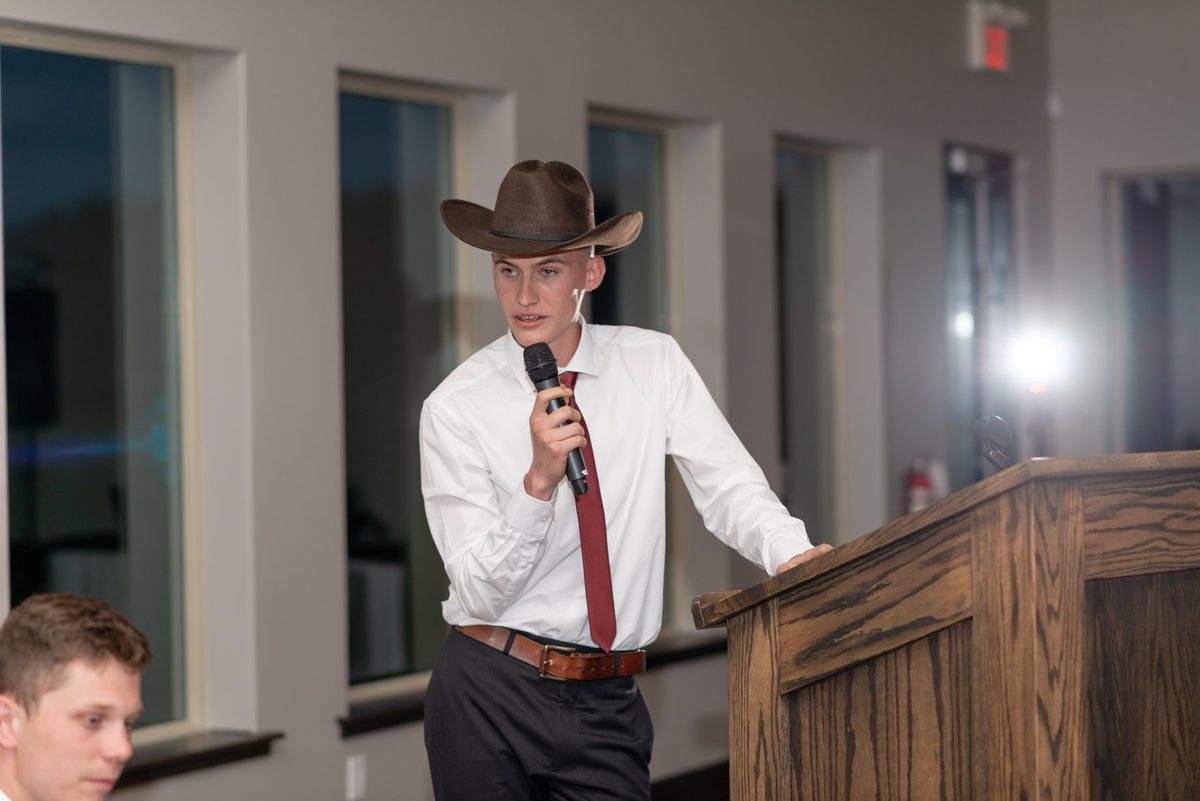Guest in a cowboy hat giving a toast at the podium during the reception at Links of Kent