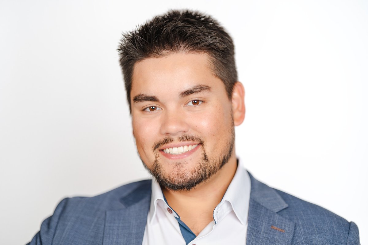 Businessman in a blazer and open-collar shirt against a white backdrop, a professional headshot taken in Chatham-Kent