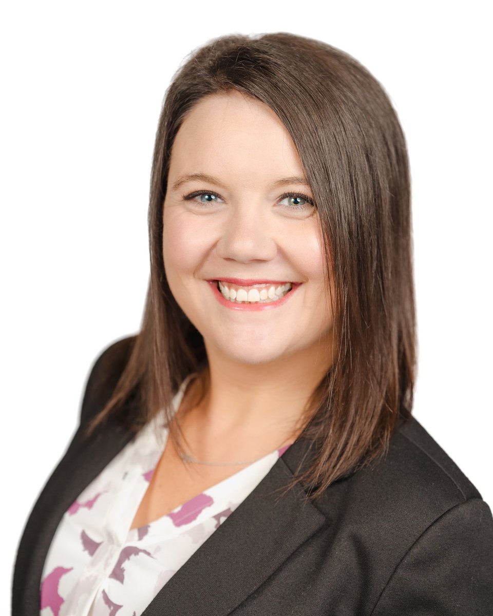 Smiling businesswoman in a black blazer against a clean white backdrop, a professional headshot taken in Chatham-Kent