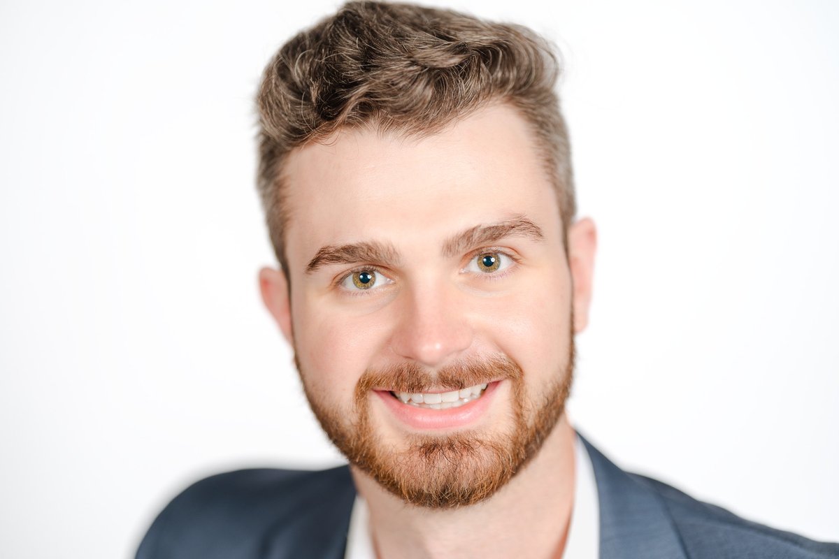 Bearded businessman in a blazer smiling against a bright white backdrop, a professional headshot for Chatham-Kent and Windsor businesses